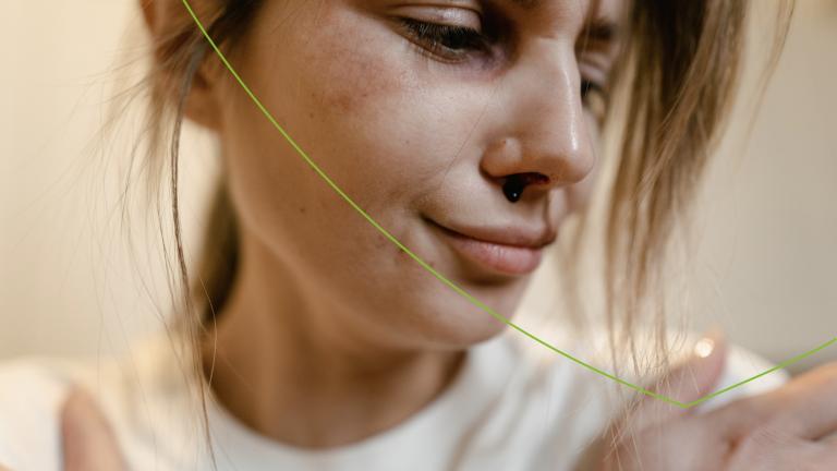 Vrouw kijkt somber en heeft bloedneus