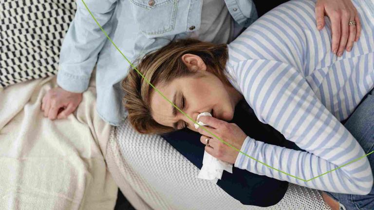 Vrouw ligt met zakdoek in haar hand bij een bijholteontsteking