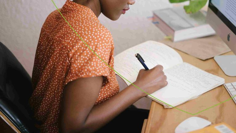 Vrouw schrijft in een schrift